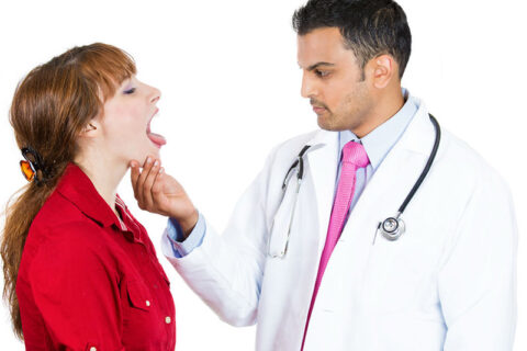 a doctor examining a person's throat
